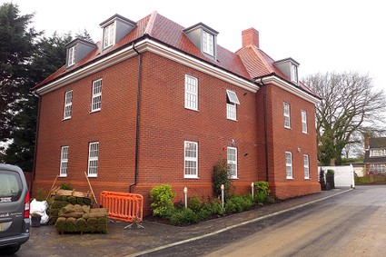 red brick block of flats, two storeys plus dormer windows