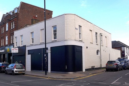 Boarded up shop, with the boards painted blck