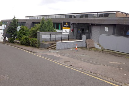 squat commercial building on a sloping road