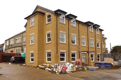 three storey block of flats nearing completion, yellow brick