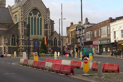 traffic lane blocked with red and white blocks, church in background